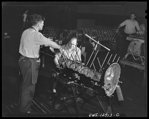 Detroit, Michigan. Assembly of Rolls Royce engines at the Packard motor car company. Driving cylinder hold down studs into the upper crankcase