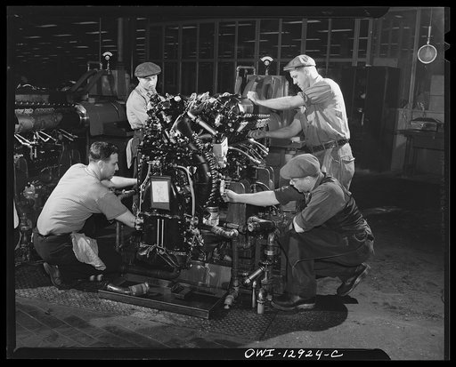Detroit, Michigan. Assembly of Rolls Royce engines at the Packard motor car company. Final installation of engine at a flush-in stand where engine first gets a running test