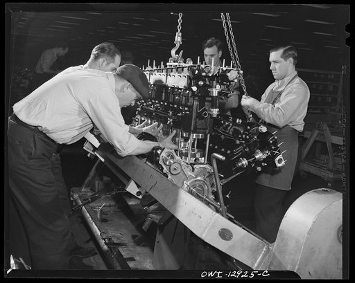 Detroit, Michigan. Assembly of Rolls Royce engines at the Packard motor car company. Adjusting pistons to a cylinder bank