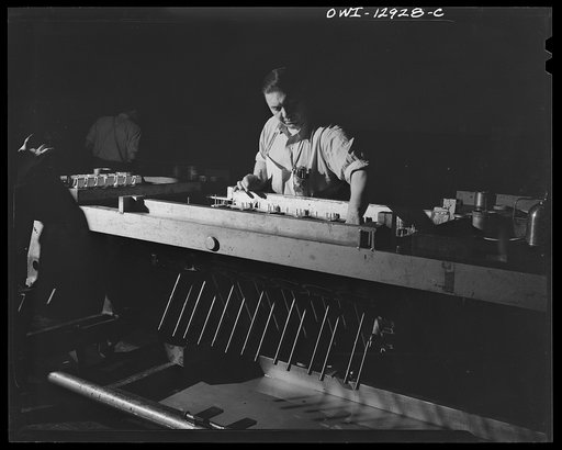 Untitled photo, possibly related to: Detroit, Michigan. Assembly of Rolls Royce engines at the Packard motor car company. Putting wire in protectors to prevent rods from damaging the crank case