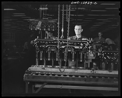 Detroit, Michigan. Assembly of Rolls Royce engines at the Packard motor car company. Removing a cylinder head from the sub-assembly line