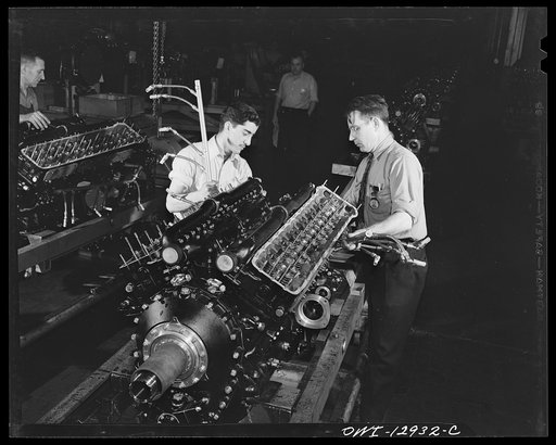 Detroit, Michigan. Assembly of Rolls Royce engines at the Packard motor car company. Installation of the exhaust harness into an engine assembly