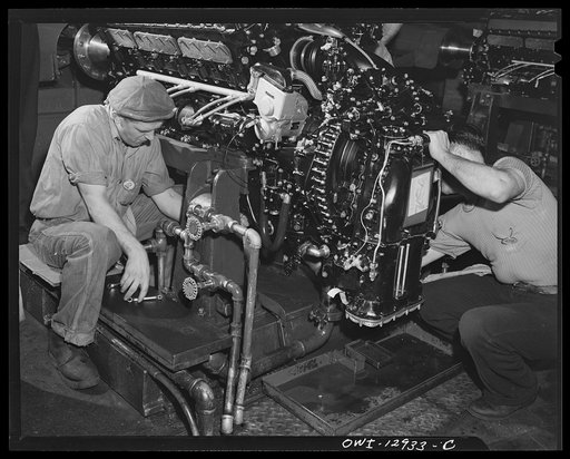 Detroit, Michigan. Assembly of Rolls Royce engines at the Packard motor car company. Connecting engine at a flush-in stand