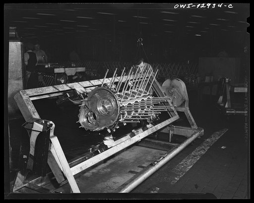 Detroit, Michigan. Assembly of Rolls Royce engines at the Packard motor car company. Turning the crankcase over in a dolly before dropping the crankshaft
