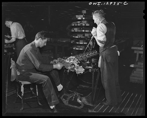 Detroit, Michigan. Assembly of Rolls Royce engines at the Packard motor car company. Driving studs into the upper crankcase