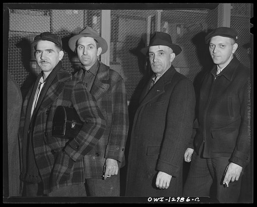 Detroit, Michigan. Assembly of Rolls Royce engines at the Packard motor car company. Workmen waiting to go home at the end of the day