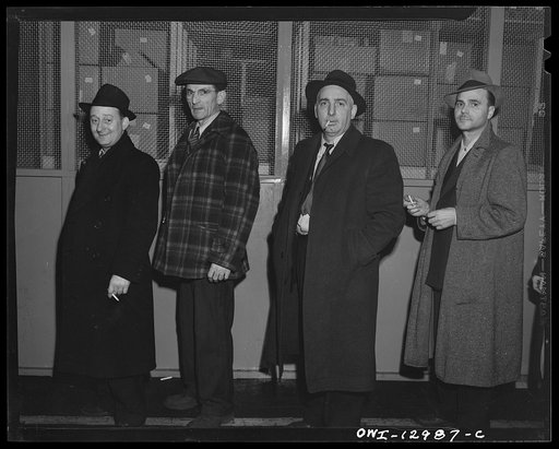 Detroit, Michigan. Assembly of Rolls Royce engines at the Packard motor car company. Workmen waiting in line to go home