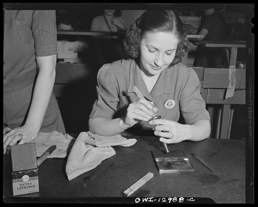 Detroit, Michigan. Assembly of Rolls Royce engines at the Packard motor car company. Stamping valves with quality marks after inspection