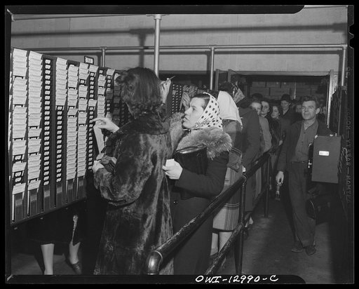 Detroit, Michigan. Assembly of Rolls Royce engines at the Packard motor car company. Checking out at the end of the day