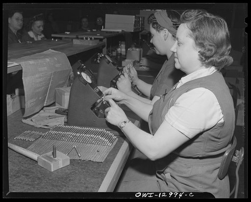 Detroit, Michigan. Assembly of Rolls Royce engines at the Packard motor car company. Checking pitch diameter of threaded parts with an inspector