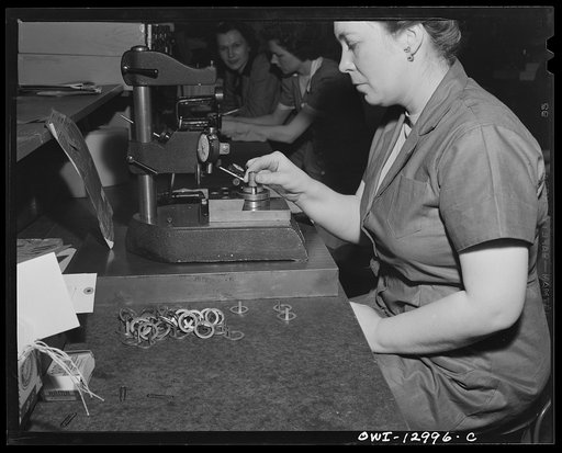 Detroit, Michigan. Assembly of Rolls Royce engines at the Packard motor car company. Checking flatness of tab washer with a dial indicator and fixture