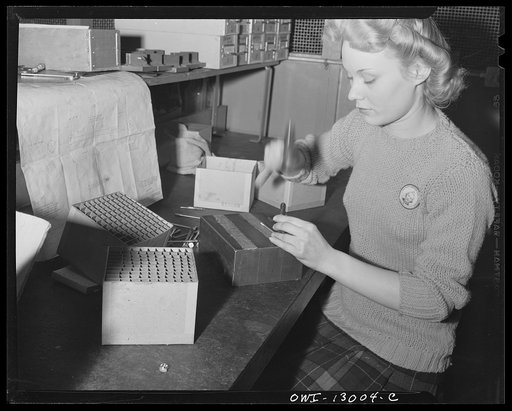 Detroit, Michigan. Assembly of Rolls Royce engines at the Packard Motor Car Company. Stamping "latest alteration" letter on bolts