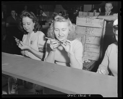 Detroit, Michigan. Assembly of Rolls Royce engines at the Packard Motor Car Company. Quality stamping parts already inspected by the Army. Notice the long lacquered nails of the girl