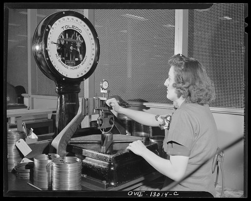 Detroit, Michigan. Assembly of Rolls Royce engines at the Packard Motor Car Company. Checking the tension of a piston ring by "weighing" on scales