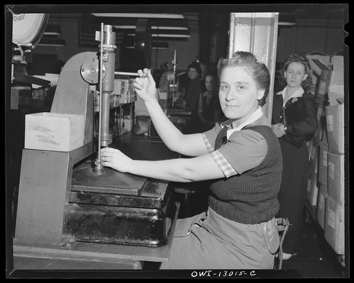 Detroit, Michigan. Assembly of Rolls Royce engines at the Packard Motor Car Company. Checking valve springs with an Arbor press for tension