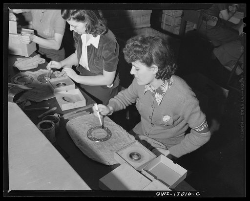 Detroit, Michigan. Assembly of Rolls Royce engines at the Packard Motor Car Company. Visually inspecting and marking super charger clutch plates