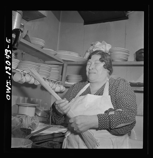 Untitled photo, possibly related to: New York, New York. New Year's Eve family party of the Di Costanzo family, owners of Marconi's Restaurant on Mulberry Street. Mamma supervising the cooking of the dinner in the kitchen