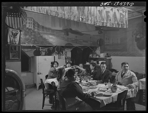 New York, New York. The Di Costanzo family, owners of a restaurant on Mulberry Street, hold their annual family dinner in the restaurant on New Year's Eve. There are few customers on that night. At left is a flag and a picture of their son who is in the United States Army