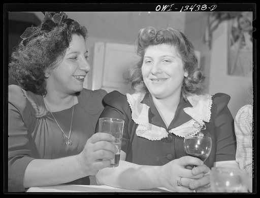 New York, New York. The Di Costanzo family, owners of a restaurant on Mulberry Street, hold their annual family dinner in the restaurant on New Year's Eve. There are few customers on that night. At left is a flag and a picture of their son who is in the United States Army. Two of the Di Costanzo gir