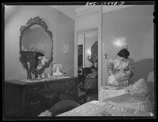 New York, New York. Mrs. Frank Romano putting her baby to bed. Her husband works in the Brooklyn Navy Yard