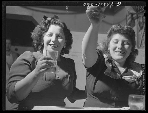 New York, New York. The Di Costanzo family, owners of a restaurant on Mulberry Street, hold their annual family dinner in the restaurant on New Year's Eve. There are few customers on that night. At left is a flag and picture of their son who is in the United States Army. Two of the Di Costanzo girls
