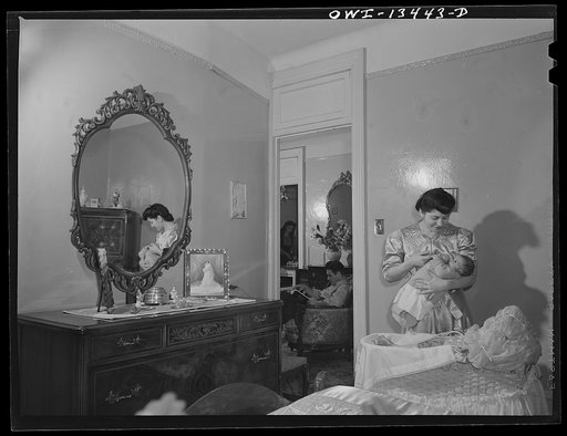 New York, New York. Mrs. Farnk Romano putting her baby to bed. Her husband works in the Brooklyn Navy Yard