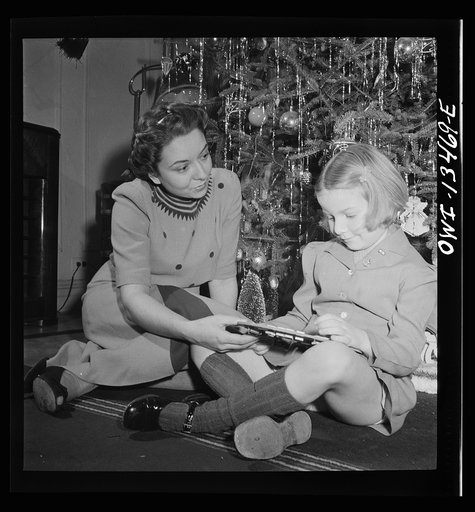 Untitled photo, possibly related to: New York, New York. Martinetti grandchild and her aunt at the Christmas tree. The pin indicates that her uncle is in the United States Army