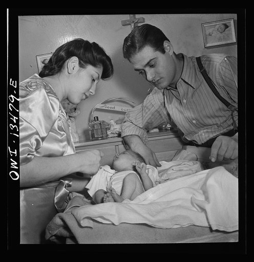 New York, New York. Mr. and Mrs. Frank Romano dressing their month-old baby for bed