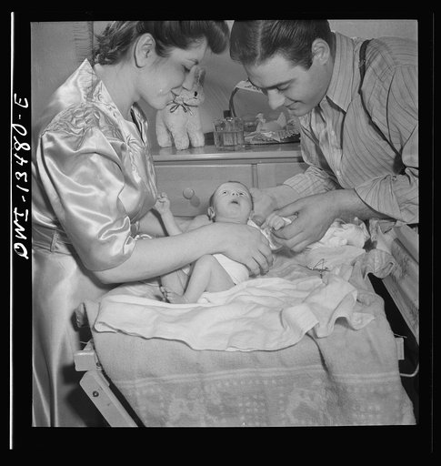 New York, New York. Mr. and Mrs. Frank Romano dressing their month-old baby for bed