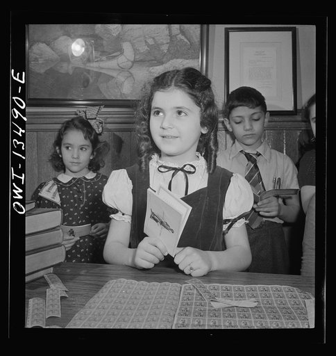 New York, New York. Children waiting in line to buy defense stamps at public school from mothers who volunteer to guard doorways and perform other duties in schools under the school defense aid program