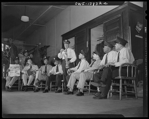 Firehouse Station No. 4. Washington, D.C. Captain J.B. Keyes yalking to some of the recently-appointed firemen about experiences at fires in the old days and showing one of the cups won by his company for the best-decorated floats in the city parades