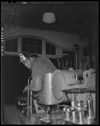 Firehouse Station No. 4. Washington, D.C. Paul Honesty, former college grid star, backs into the station house after a run. New men who have been in service a year or more are allowed to drive back to the station house so that they may become used to handling the large trucks
