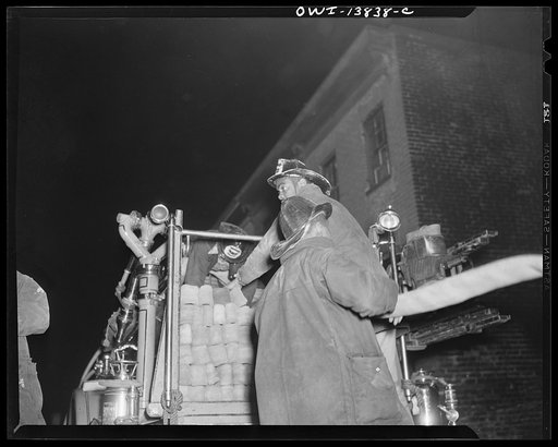 Firehouse Station No. 4. Washington, D.C. Firemen pull a large hose from the truck and the truck proceeds to the area nearer to the fire. One man stays with the hose and is responsible for attaching it to the nearest fire hydrant. He is called the layout man