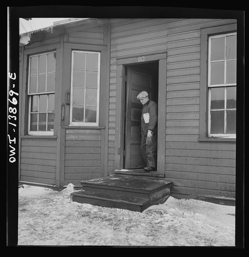 Untitled photo, possibly related to: Chicago, Illinois. Yard clerk checking cars as trains are being made up outside his window