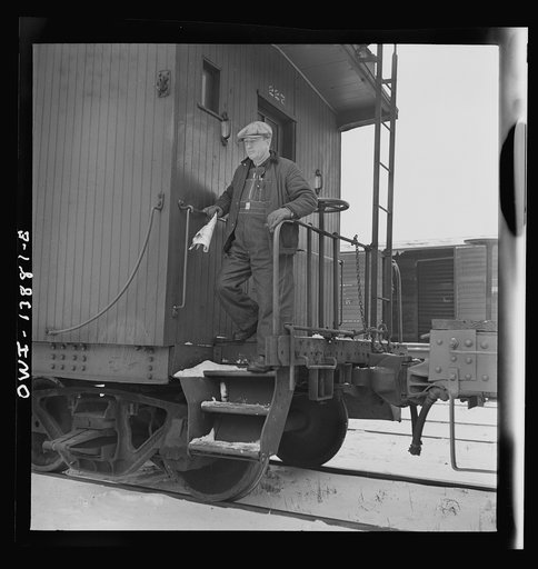 Untitled photo, possibly related to: Freight operations on the Indiana Harbor Belt railroad between Chicago, Illinois and Hammond, Indiana. The conductor uses hand brakes on the caboose to stop it as it coasts down a siding