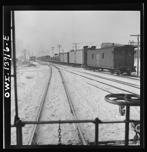 Untitled photo, possibly related to: Freight operations on the Indiana Harbor Belt railroad between Chicago, Illinois and Hammond, Indiana. The conductor uses hand brakes on the caboose to stop it as it coasts down a siding