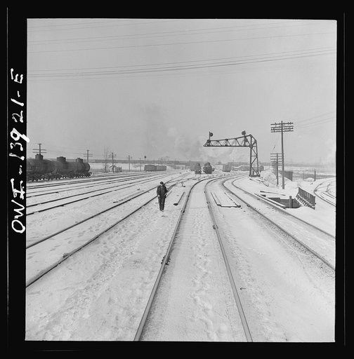 Untitled photo, possibly related to: Freight operations on the Indiana Harbor Belt railroad between Chicago, Illinois and Hammond, Indiana. The train stops for a signal and brakeman Zerkel stands beyond it flagging a train coming up from behind
