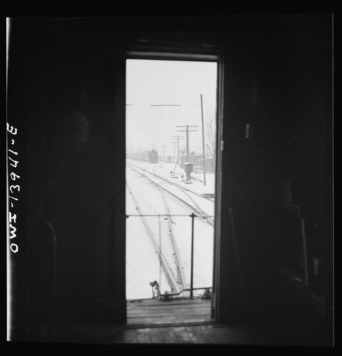 Untitled photo, possibly related to: Freight operations on the Indiana Harbor Belt railroad between Chicago, Illinois and Hammond, Indiana. When two train pass, the rear brakeman for each watches the other train and if there are no hotboxes or other damage he gives the high sign