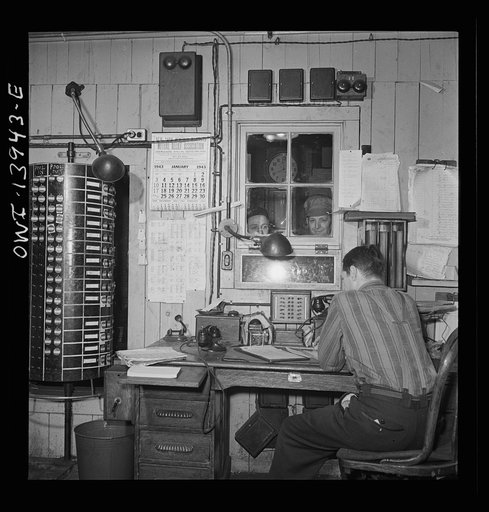 Freight operations on the Indiana Harbor Belt railroad between Chicago, Illinois and Hammond, Indiana. The engine crew, engineer and fireman, report at the roundhouse office to be assigned their engine and given orders for the day. The cylinder at the left is the pool board; it lists the names of th