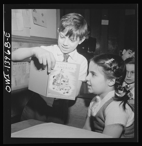 New York, New York. This boy has brought a book to Public School Eight which he is showing to fellow pupils during class discussion