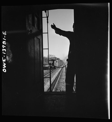 Freight train operations on the Chicago and Northwestern Railroad between Chicago and Clinton, Iowa. Every time a train is passed, the rear brakeman of each train steps out on the caboose platform, and if all is well, as in this case, gives the other brakeman the high sign
