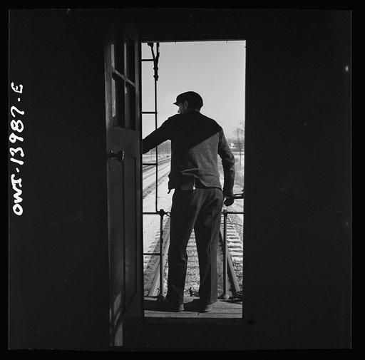 Untitled photo, possibly related to: Freight train operations on the Chicago and Northwestern Railroad between Chicago and Clinton, Iowa. Every time a train is passed, the rear brakeman of each train steps out on the caboose platform, and if all is well, as in this case, gives the other brakeman the