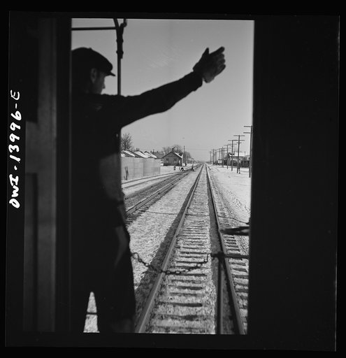 Freight train operations on the Chicago and Northwestern Railroad between Chicago and Clinton, Iowa. As the train goes through a small town, the conductor exchanges high signs with a switch tender