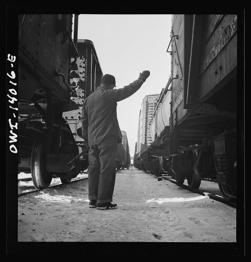 Untitled photo, possibly related to: Freight operations on the Chicago and Northwestern Railroad between Chicago and Clinton, Iowa. The rear brakeman signals the engineer to test the brakes by applying and releasing them. This is the signal for "apply"