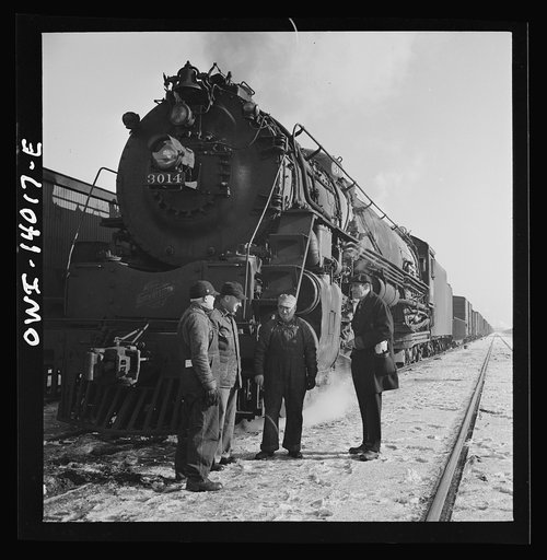 Freight train operations on the Chicago and Northwestern Railroad between Chicago and Clinton, Iowa. The crew, with exception of the fireman, chat while waiting for orders to pull out