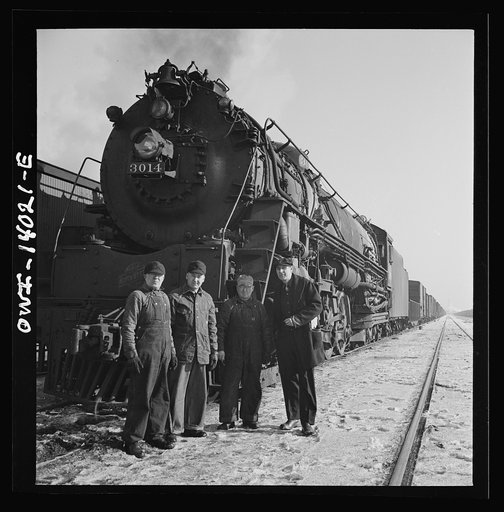 Freight train operations on the Chicago and Northwestern Railroad between Chicago and Clinton, Iowa. The fireman is in the cab but the rest of the crew (head man, rear man, engineer and conductor) pose by their train