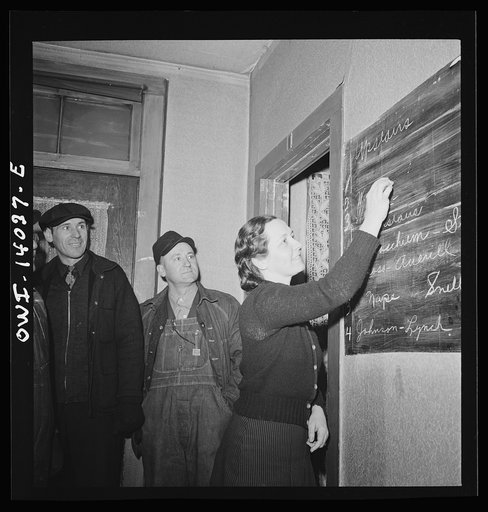 Clinton, Iowa. Miss Lucille Disher, whose father was a railroad worker for forty years, runs a rooming house for railroad workers. Here she is assigning rooms to a crew that just came in. The men's names on the blackboard enable the "caller" to find and wake them in the morning