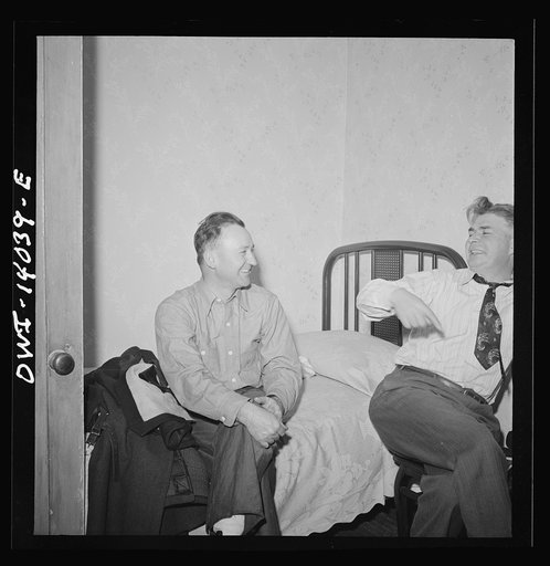 Untitled photo, possibly related to: Clinton, Iowa. Jim Cross, brakeman, visiting Clarence Averill, another brakeman on the Chicago and Northwestern Railroad. He has to watch the time because he goes to work at midnight