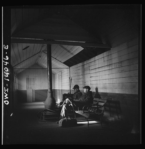 Untitled photo, possibly related to: Freight train operations on the Chicago and Northwestern Railroad between Chicago and Clinton, Iowa. At the end of the trip, Conductor Wolfsmith waits at the little railroad station for a suburban train to take him back home to Chicago. A welder, who works at the