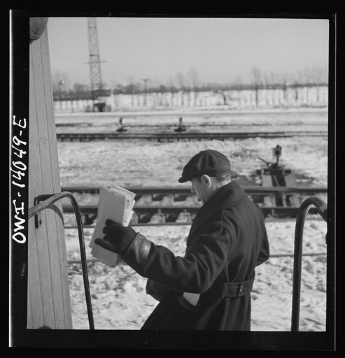 Freight trains operations on the Chicago and Northwestern Railroad between Chicago and Clinton, Iowa. Clutching his bills, Conductor Wolfsmith hops off the caboose as the train passes the yard office on its way into the receiving yard